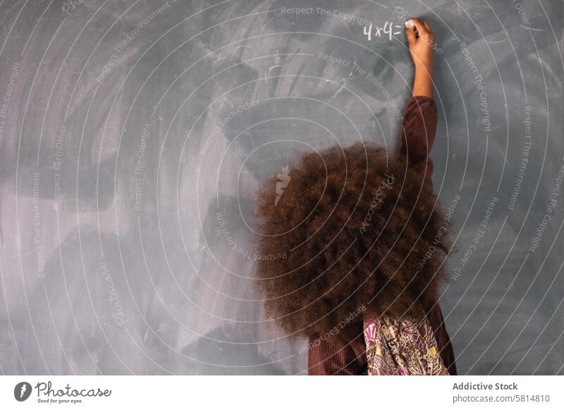 Schwarzes Mädchen schreibt auf Tafel im Klassenzimmer Pupille Mathematik Beispiel lösen schreiben Lektion ethnisch Afroamerikaner schwarz Schule Schulmädchen