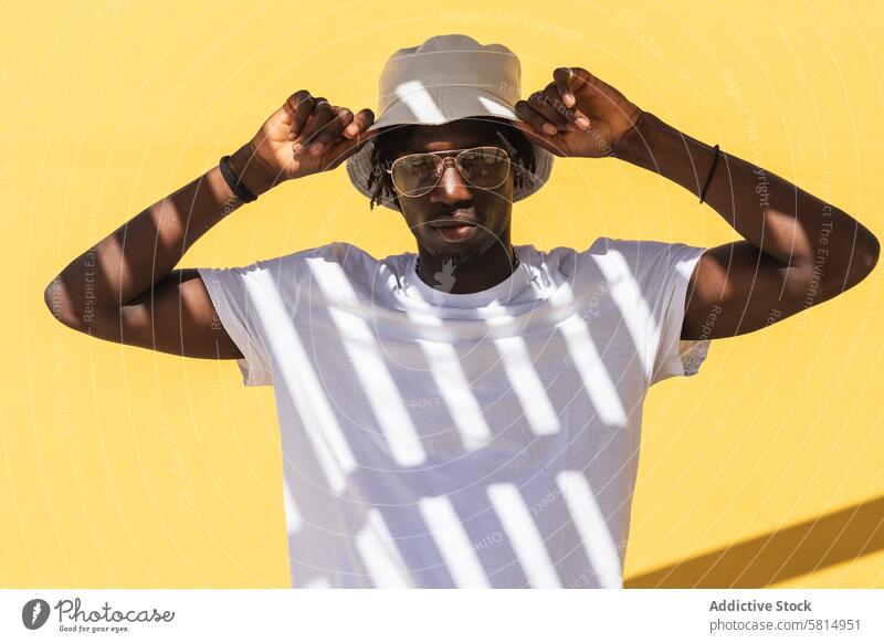 Junger schwarzer Mann mit Panamahut Hipster Hut Schatten Streifen Stil Sonnenbrille trendy farbenfroh Afroamerikaner ethnisch männlich Brille Kopfbedeckung Typ