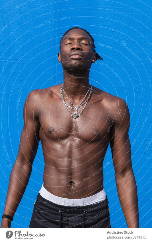 Muskulöser schwarzer Mann mit nacktem Oberkörper muskulös ohne Hemd stark selbstbewusst anketten nackter Torso passen maskulin physisch jung Afroamerikaner