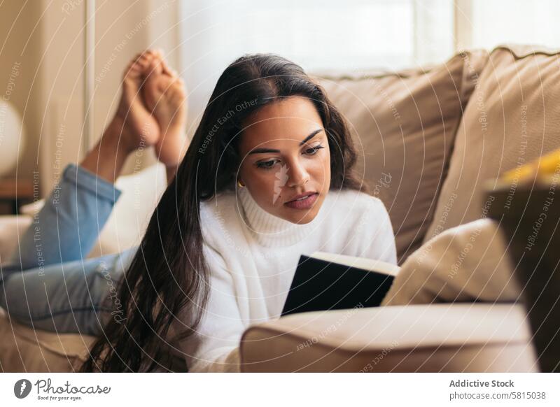 Entspannen zu Hause: Junge Frau liest ein Buch auf dem Sofa lesen heimwärts Erholung Ruhe Komfort Gelassenheit Zufriedenheit Freizeit gemütlich Lifestyle
