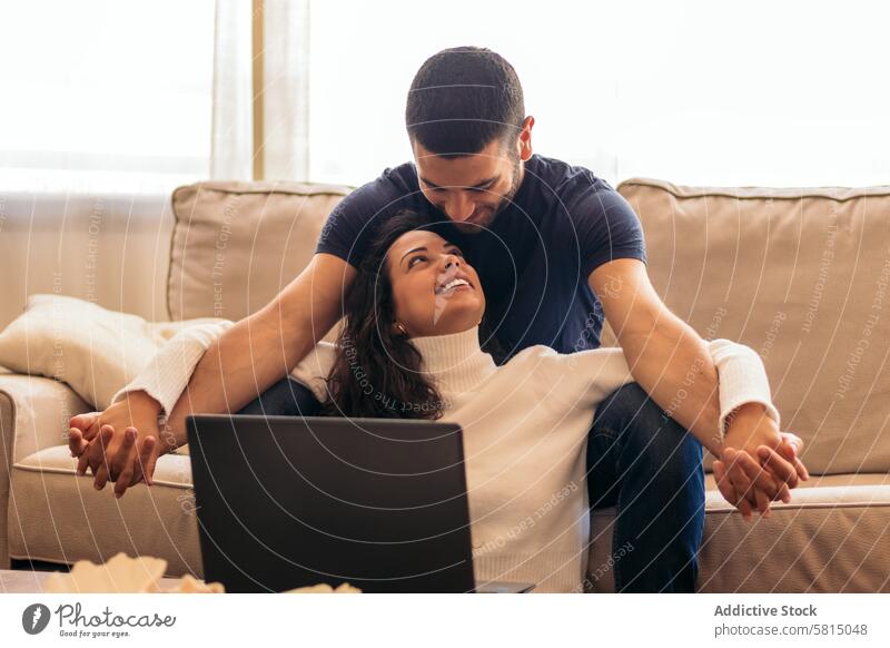Junges Paar genießt einen Film auf dem Laptop zu Hause Sofa heimwärts Freizeit Erholung Technik & Technologie digital Streaming Entertainment Genuss gemütlich
