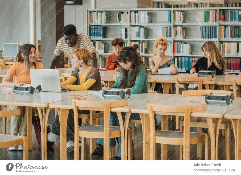 Multiethnische Studenten machen Hausaufgaben in einer modernen Bibliothek Klassenkamerad reden lernen Schüler Zusammensein Universität Bildung Wissen fettarm