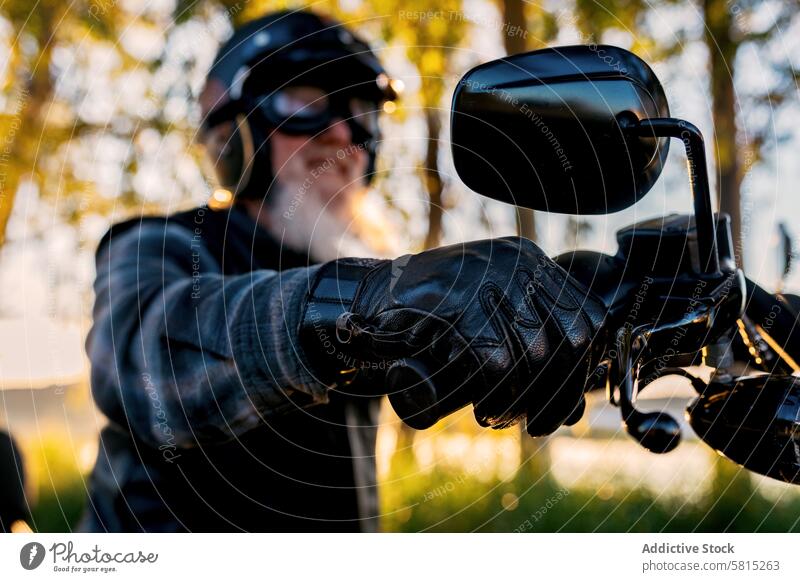 Ältere Biker genießen eine Motorradfahrt bei Sonnenuntergang Mitfahrgelegenheit Senior Mann reif Vollbart Schutzhelm Schutzbrille Lenker Handschuhe Freizeit