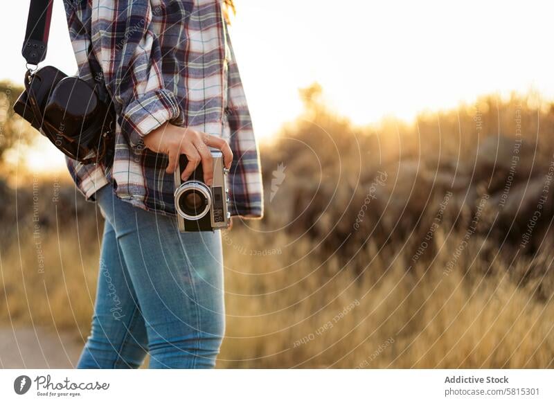 Unbekannte Frau fotografiert mit analoger Kamera auf dem Lande Foto Lifestyle jung Mädchen Fotografie altehrwürdig Fotokamera retro reisen Sonnenuntergang
