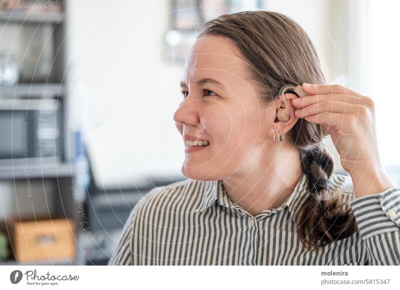 Frau trägt Hörgerät am Ohr auf Gehör Person taub Unterstützung Gesundheit Gerät Erwachsener Behinderung 30s weiß Lächeln Porträt Hemd