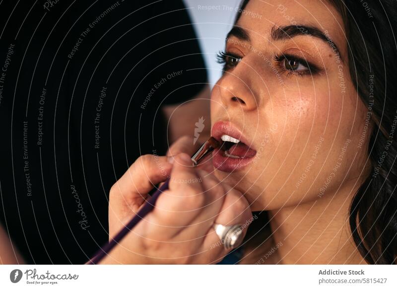 Nahaufnahme einer Frau, deren Lippen geschminkt werden Model Make-up Schönheit Künstler jung schön Blick Gesicht Glamour Kosmetik hübsch professionell Kaukasier