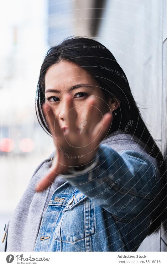 Asiatische brünette Frau mit langen Haaren lehnt an der Wand und schaut in die Kamera Japanisch asiatisch Asien jung Model Chinesisch Stil attraktiv Dame Straße