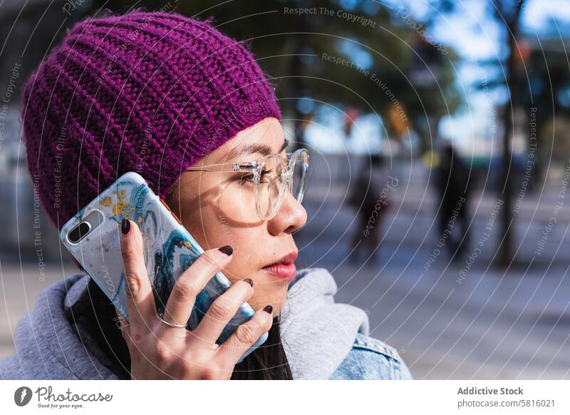 Asiatische brünette Frau mit langen Haaren lehnt an der Wand und schaut weg Japanisch asiatisch Asien jung Model Funktelefon Telefon Chinesisch Stil attraktiv