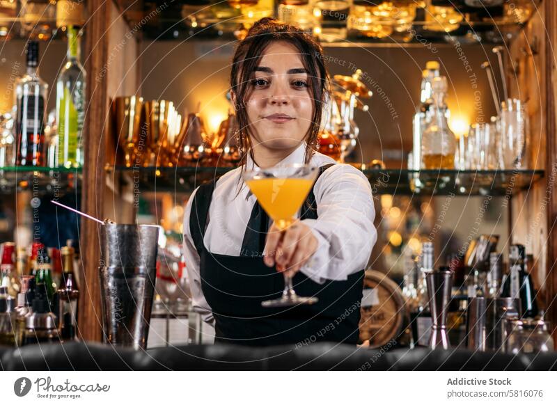 Junge Barkeeperin bietet ein Getränk an Cocktail Barfrau Cocktailbar Mixologe Nachtclub Alkohol Glas trinken Arbeit professionell Club im Innenbereich Jigger