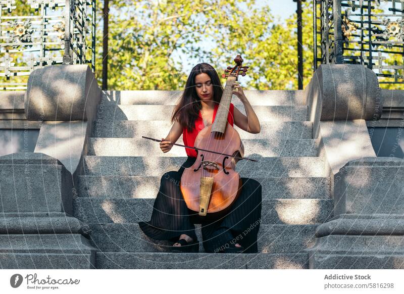 Eine junge Frau spielt im Freien Cello Musiker Instrument Konzert Leistung Künstler Musical spielen Klassik Entertainment Orchester Melodie Symphonie Klang