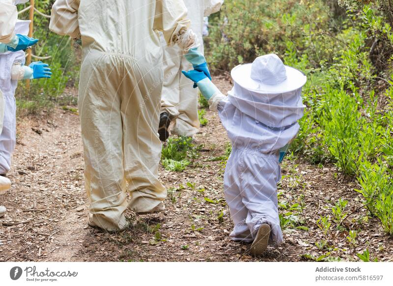 Kind und Imker halten sich im Bienenstock an den Händen Händchenhalten Bienenkorb Tracht behüten Landschaft
