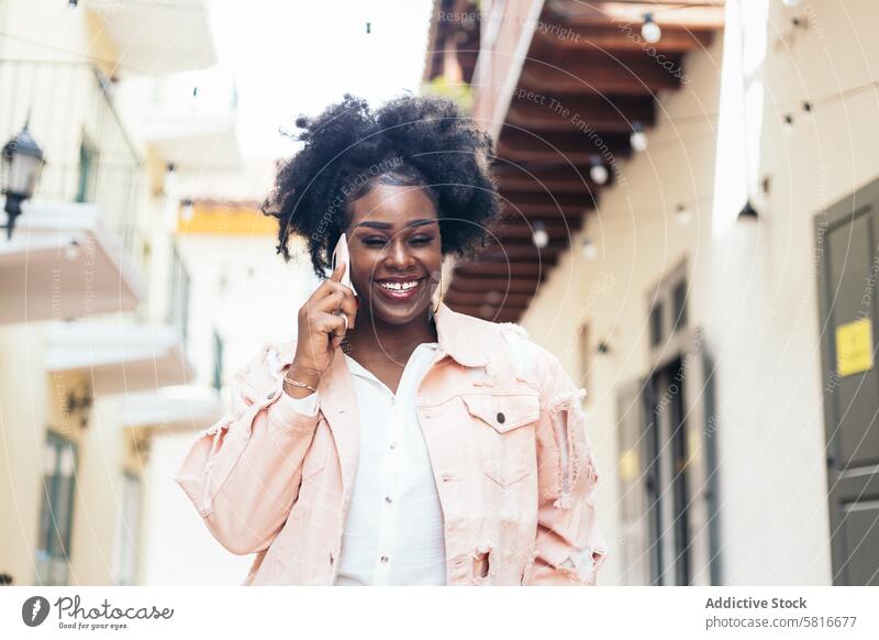 Stylish schwarze Frau zu Fuß auf der Straße der Stadt sprechen am Telefon Großstadt jung im Freien urban Mode schön Lifestyle Spaziergang lässig Menschen