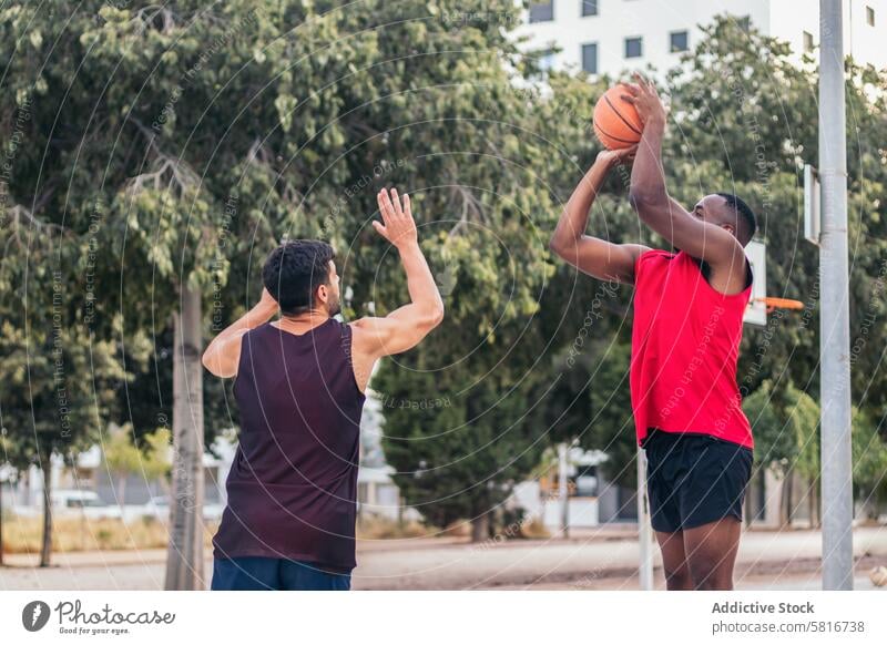 Männer dominieren den Basketballplatz Freunde rassenübergreifend Sport Spaß Korb jung Ball Spiel Gericht Team Lifestyle Spieler urban Training im Freien spielen