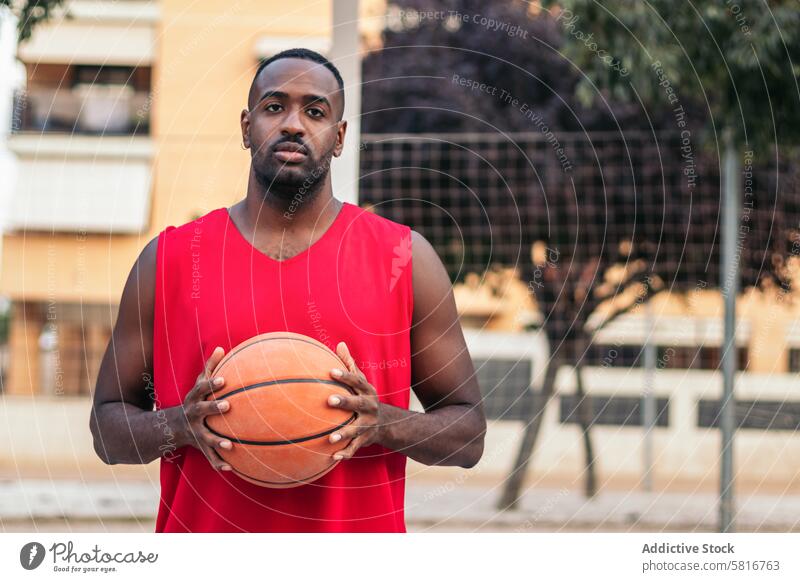 Selbstbewusster Basketballspieler, der den Ball mit Entschlossenheit hält Sport Korb jung Spiel Gericht Lifestyle Spieler urban im Freien spielen sportlich