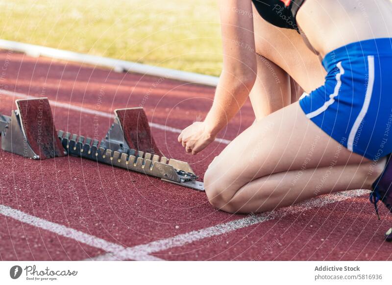 Eine Sportlerin bereitet sich auf einen Lauf auf einer Leichtathletikbahn vor. Athlet Fitness Lifestyle Bahn Läufer Training Übung Gesundheit Frau aktiv passen