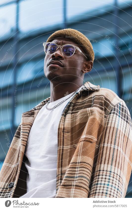 Stilvoller afroamerikanischer Mann auf der Straße ruhend Großstadt lässig urban modern Stirnrunzeln Outfit männlich schwarz ethnisch Afroamerikaner jung trendy