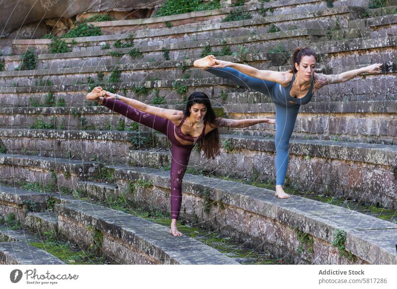 Konzentrierte Frauen, die in Hand-to-Toe-Pose stehen und Yoga machen beweglich üben Gleichgewicht Hand-zu-Fuß-Pose hasta padangusthasana Dehnung Zusammensein
