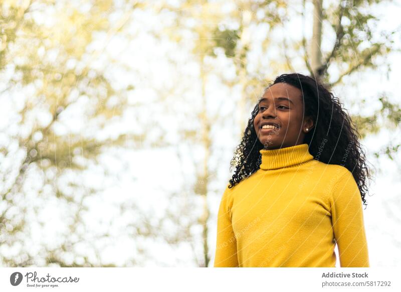 Afroamerikanisches Mädchen, das lächelnd in einem Park spazieren geht Frau Glück jung Lifestyle Afrikanisch Amerikaner Lächeln Sommer Natur Freizeit Menschen