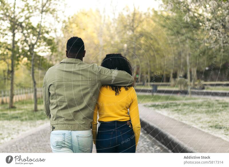 Rückenansicht eines afroamerikanischen Paares beim Spaziergang in einem Park Frau Liebe Zusammensein Mann laufen Freund männlich Menschen Lifestyle Freundin
