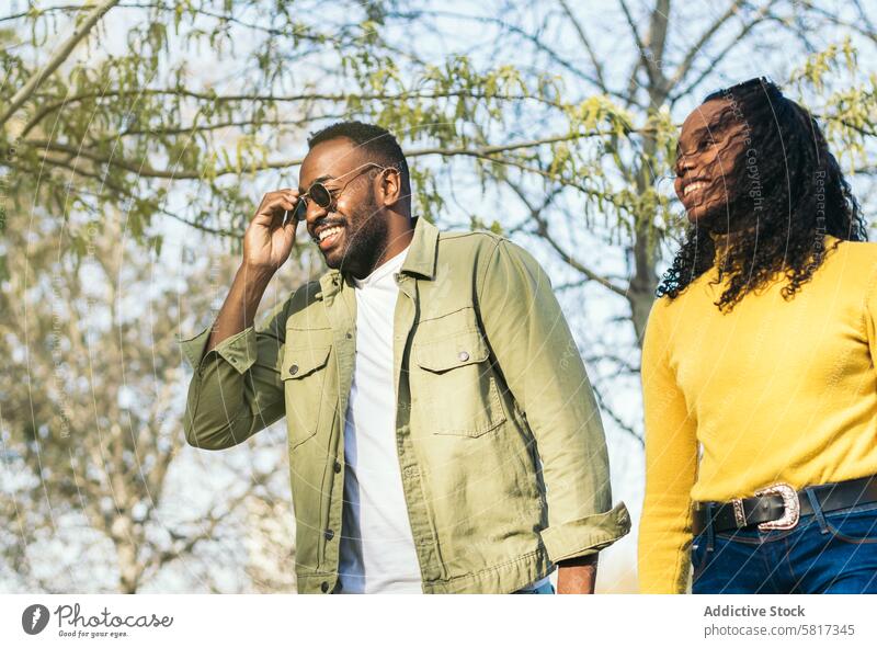 Hübscher afro-amerikanischer junger Mann und seine Schwester gehen in einem Park gutaussehend schwarz männlich Glück Amerikaner Afro-Look Afrikanisch Lifestyle