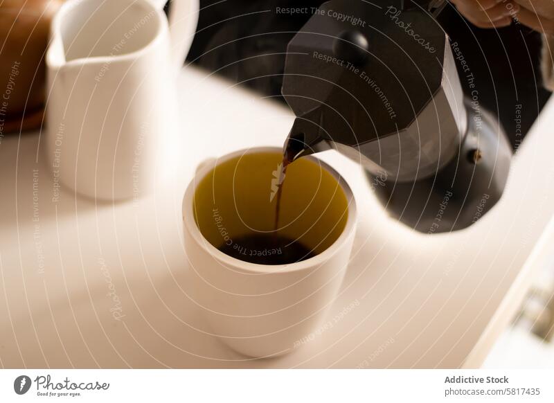 Einschenken von Kaffee in eine Tasse in einer Küche. trinken Hand Getränk Café Espresso Koffein heiß eingießen Becher Frühstück Morgen Hintergrund Menschen