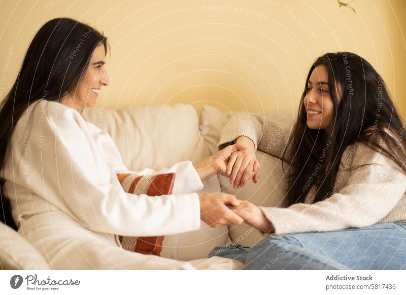 Mutter und Tochter lächelnd und halten die Hände Erwachsener Liebe Sofa Beteiligung heimwärts sprechend Lifestyle Familie Frau Menschen Mädchen reif Eltern