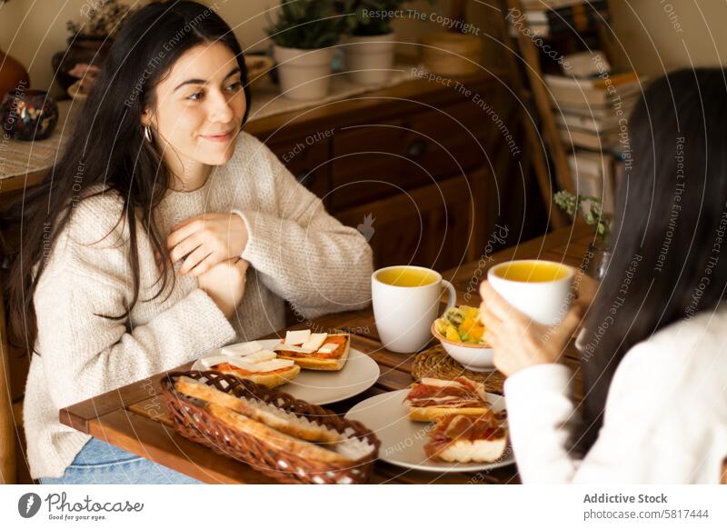 Schöne junge Frau beim Frühstück mit ihrer Mutter. Tochter Familie Erwachsener heimwärts Glück Kaukasier Mädchen Lächeln Lebensmittel Menschen Morgen Eltern
