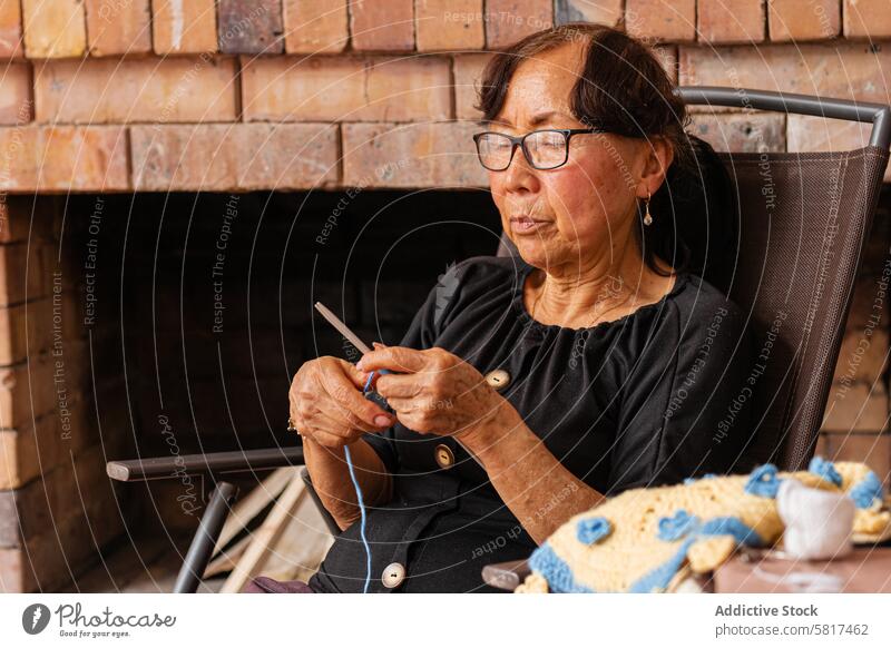 Gelassenheit beim Nähen. Ältere asiatische Frau strickt zu Hause. aktiv Alterung Kunst und Handwerk künstlerisch künstlerischer Ausdruck Authentizität Pflege