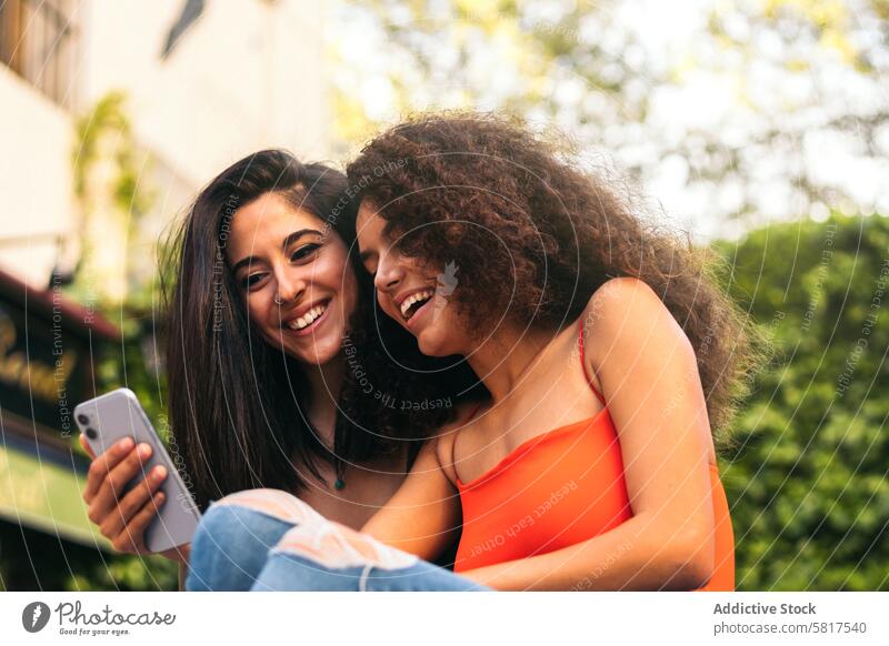 zwei schöne Frauen sitzen und benutzen ihre Handys jung Glück Technik & Technologie Telefon Mobile Sitzen Smartphone Zusammensein Lifestyle Blick Menschen