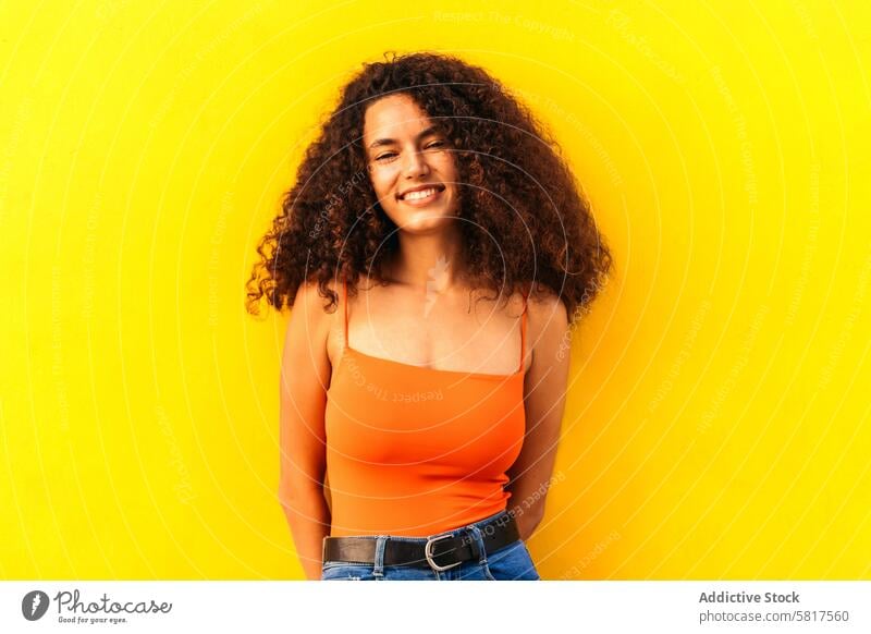 schöne afro Frau Porträt lehnt an einer gelben Wand Afro-Look Afrikanisch schwarz jung attraktiv Amerikaner lässig heiter Schönheit Glück Menschen Blick Mädchen