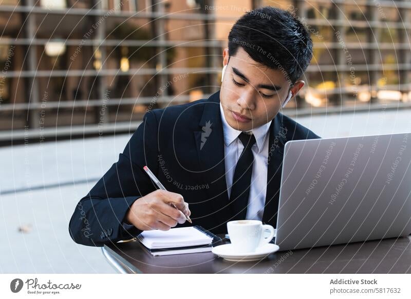 Seriöser männlicher Unternehmer im Anzug arbeitet in einem Cafe Geschäftsmann zur Kenntnis nehmen Notebook Café Arbeit abgelegen Plan Veranstalter schreiben