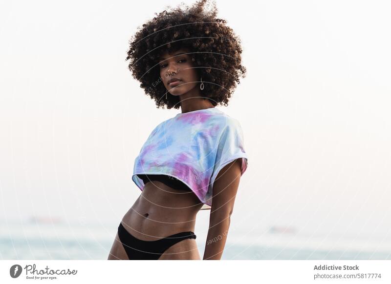 Emotionslose schwarze Frau am Meeresufer stehend MEER Bikini Sommer Feiertag Top Urlaub ethnisch Afroamerikaner Frauenunterhose krause Haare Afro-Look Frisur