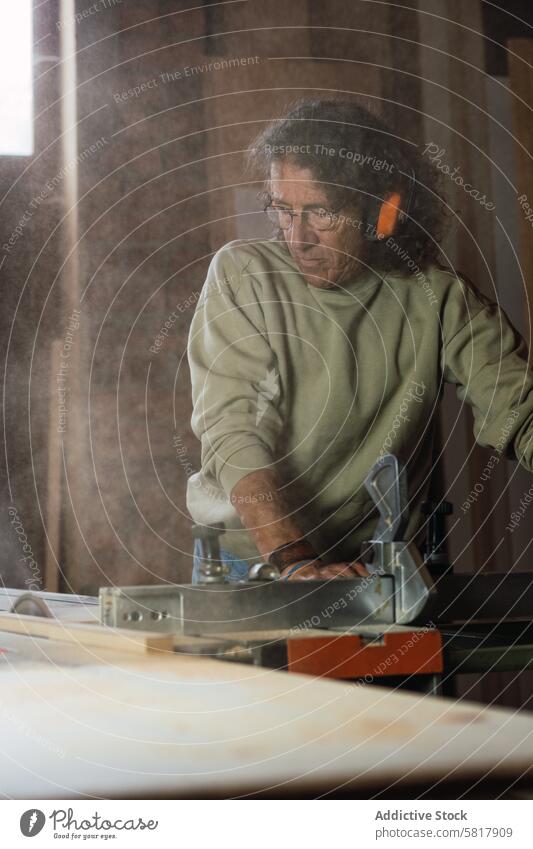 Tischler beim Schneiden von Holz mit einer Kreissäge in einer Tischlerei Tischlerin kreisrund Säge Holzarbeiten geschnitten Staubwischen Mann Werkstatt