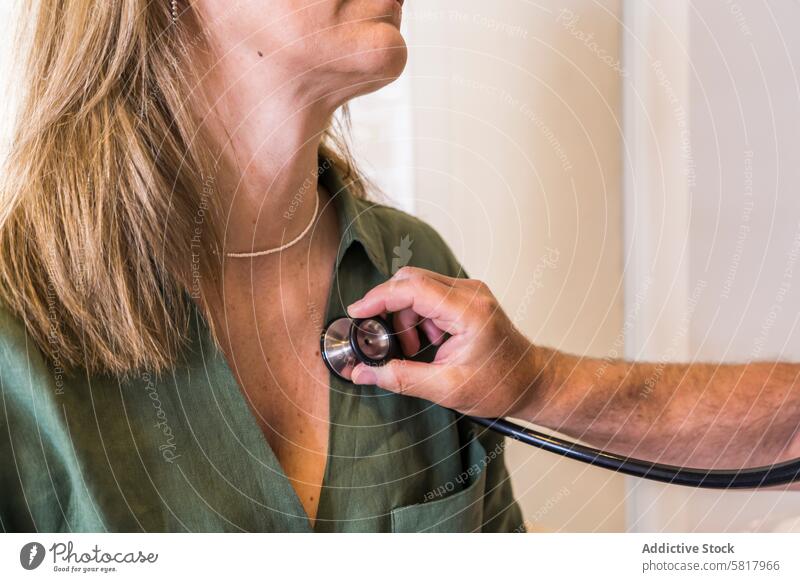 Nahaufnahme einer Ärztin, die mit einem Stethoskop den Herzschlag ihres Patienten überprüft. Analysieren Gesundheitswesen und Medizin Beruf Berufliche Tätigkeit