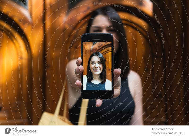 Erfreute Frau, die in der Stadt ein Selfie mit ihrem Smartphone macht Mobile Telefon Selbstportrait heiter Spaß haben Foto Gedächtnis Moment Glück Gerät positiv