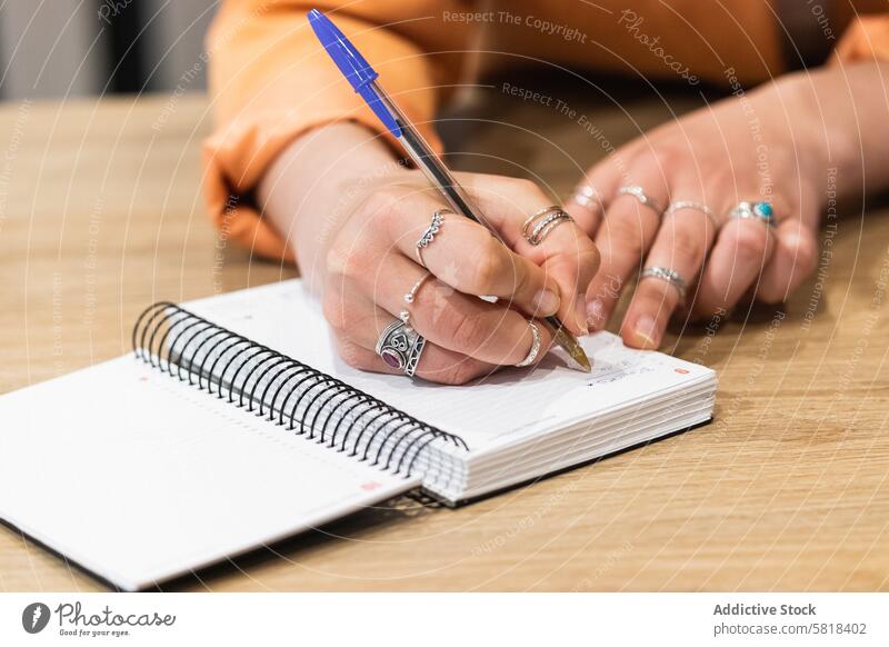 Crop-Frau macht sich Notizen in einem Notizbuch während der Arbeit in einem Cafe freiberuflich zur Kenntnis nehmen schreiben Notebook Projekt Planer Netbook Job