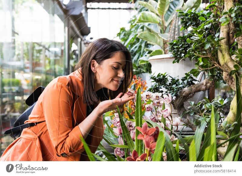 Fröhliche Frau wählt Blumen in einem Gartencenter aus Markt wählen Blütezeit pflücken Kunde Zentrum Großstadt Pflanze frisch organisch Gärtner Aroma wachsen