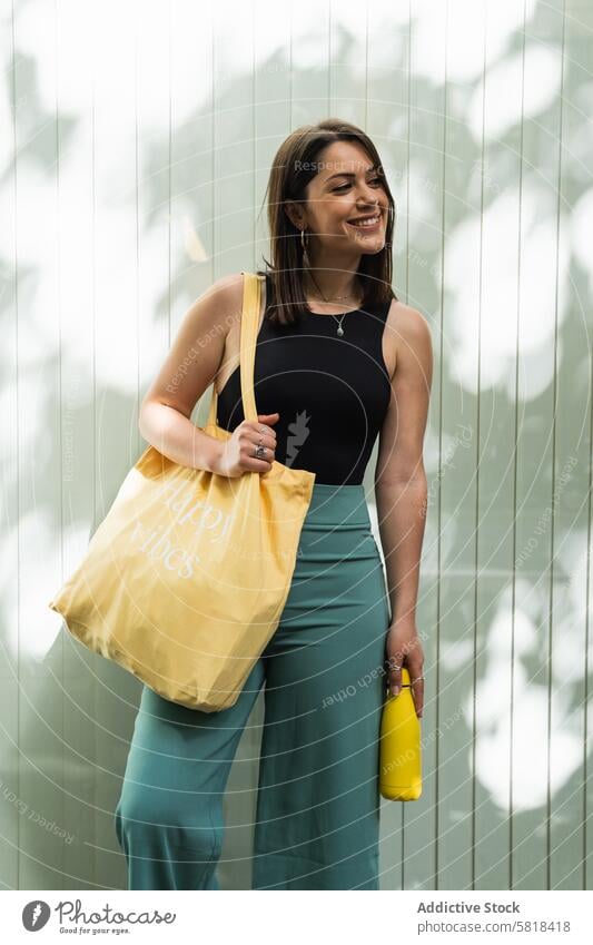 Glückliche Frau mit umweltfreundlicher Tasche in der Stadt Einkaufstasche wiederverwenden keine Verschwendung Straße Großstadt Ökologie reduzieren nachhaltig