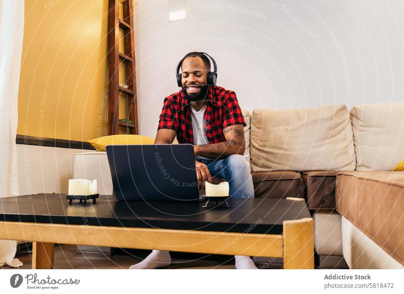Afroamerikanischer Mann, der mit seinem Laptop zu Hause einen Videoanruf tätigt Computer Afroamerikaner heimwärts Internet abgelegen online benutzend schwarz