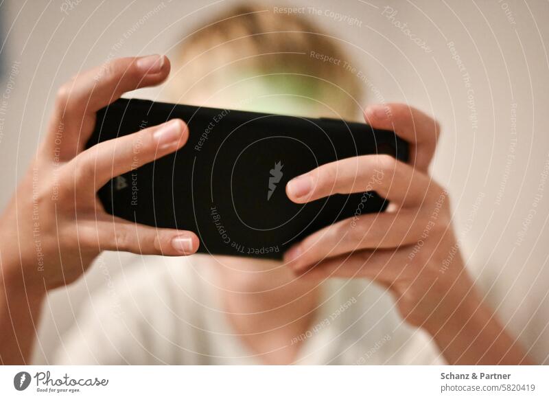 Kind spielt auf einem Smartphone Bildschirm Spielen Technologie Handy Unterhaltung Nahaufnahme Hände Junge Fokus Digital Mobilgerät Konzentration Freizeit