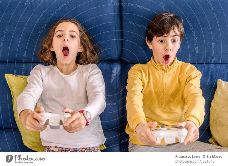 Begeisterte Kinder tauchen in Konsolenspiele ein Spiel spielen Aufregung Freude Regler Video Technik & Technologie Entertainment Freizeit Spaß Fokus jung