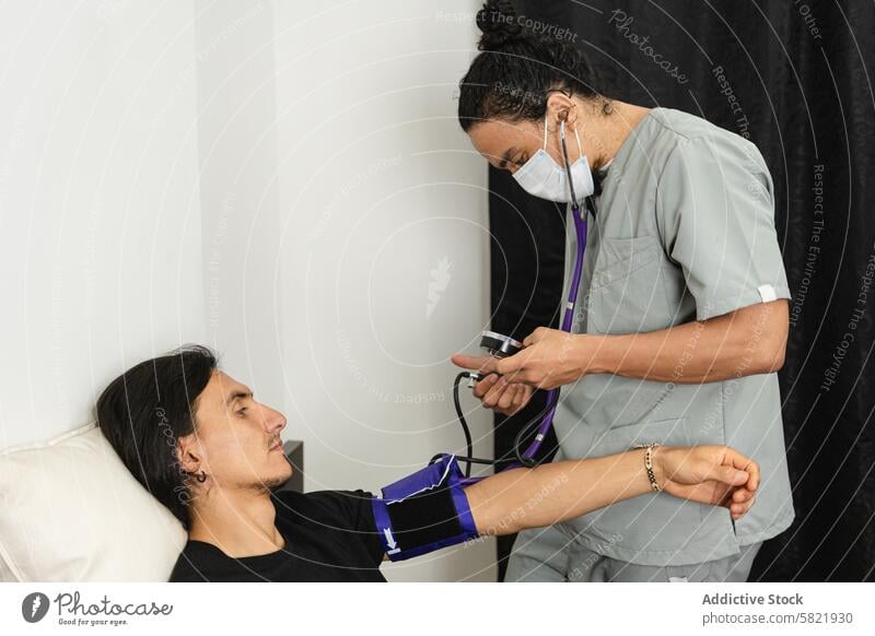 Krankenschwester prüft den Blutdruck eines Patienten während einer medizinischen Untersuchung Krankenpfleger geduldig Prüfung Gesundheit überwachen klinisch