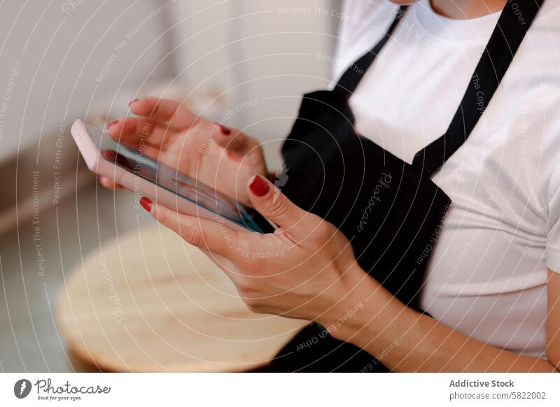 Kochbegeisterter, der auf seinem Smartphone Kuchenrezepte durchsucht Person Essen zubereiten Rezept Schürze backen Frau Hand Gerät Mobile Technik & Technologie
