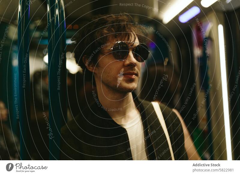 Trendiger junger Mann mit Sonnenbrille in der U-Bahn trendy modisch Zug urban Lifestyle lässig Stil männlich Pendler Großstadt Verkehr Öffentlich Mode cool