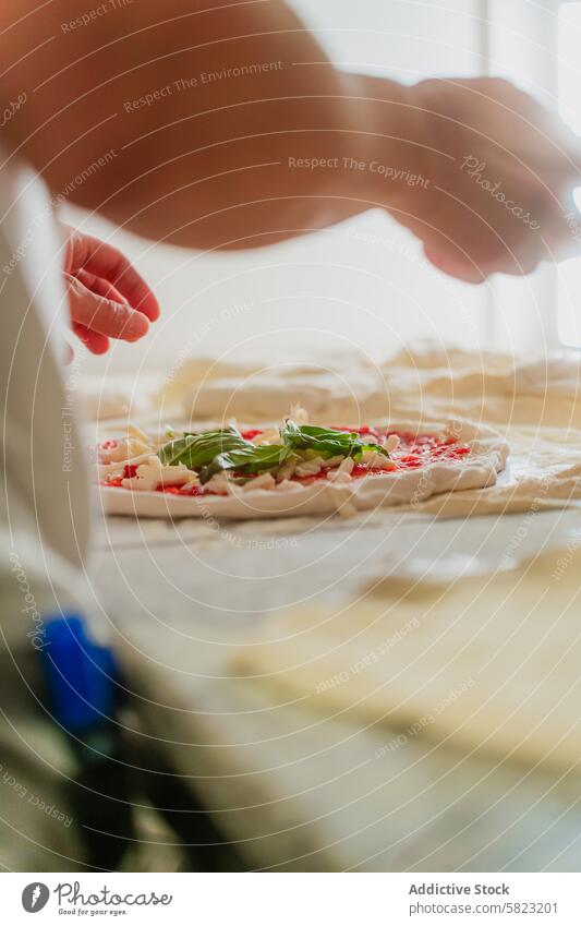 Frische Pizza in einer Pizzeria zubereiten Küchenchef Belag Tomate Basilikum Käse Teigwaren kulinarisch Vorbereitung Lebensmittel frisch Essen zubereiten anonym