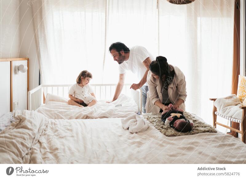 Familienzeit mit einem Neugeborenen und einem Kleinkind in einem gemütlichen Schlafzimmer neugeboren Eltern Mutter Vater Baby Kind Bett