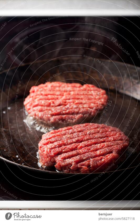 zwei Rindfleisch-Patties in einer Eisenpfanne Patty Pfanne Lebensmittel Kochen niemand Scheibe Burger Hackfleisch roh gemahlen Zubereitung gehackt Grillen Fett