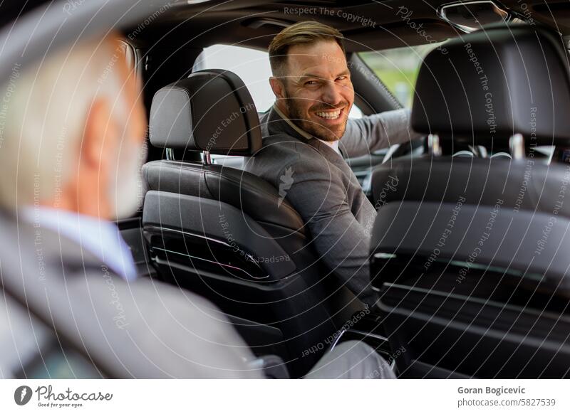 Lächelnder Fahrgast, der sich mit dem Fahrer in einem modernen Auto freundlich unterhält Fahrzeug Passagier Gespräch PKW Rückseite Sitz Kameradschaftlichkeit