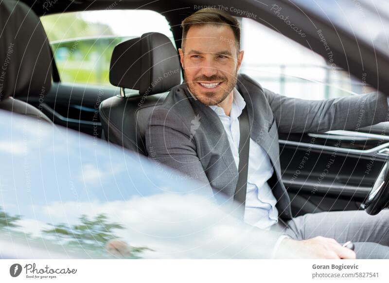 Lächelnder Mann, der eine sonnige Fahrt in einem modernen Auto genießt fahren PKW Innenbereich lenken Rad Straße Ausflug Genuss Tag Transport Fahrer Fahrzeug