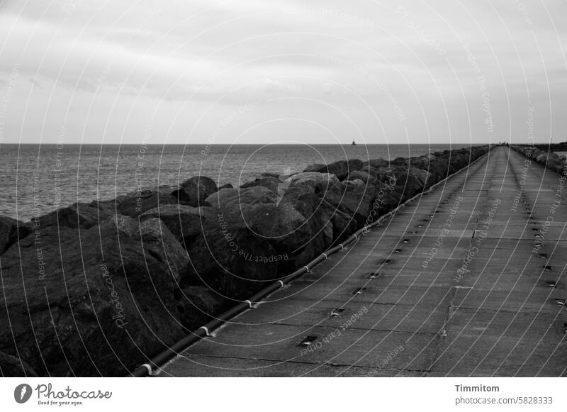 Auf die Plätze… Mole Beton Steine Befestigung Nordsee Wasser Horizont Dänemark Himmel Wolken Menschenleer Schwarzweißfoto Rohre Leitungen
